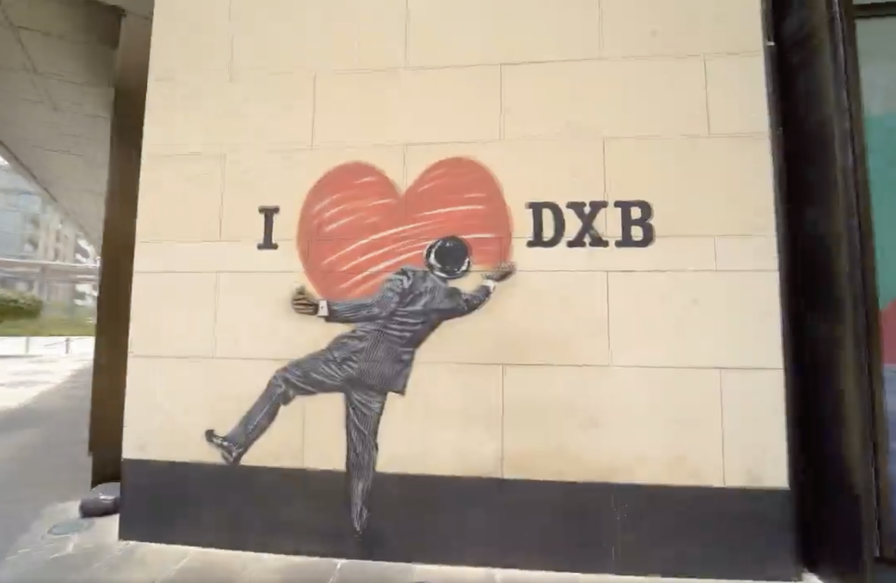 A drawing on a wall that shows a man expressing his love for Dubai